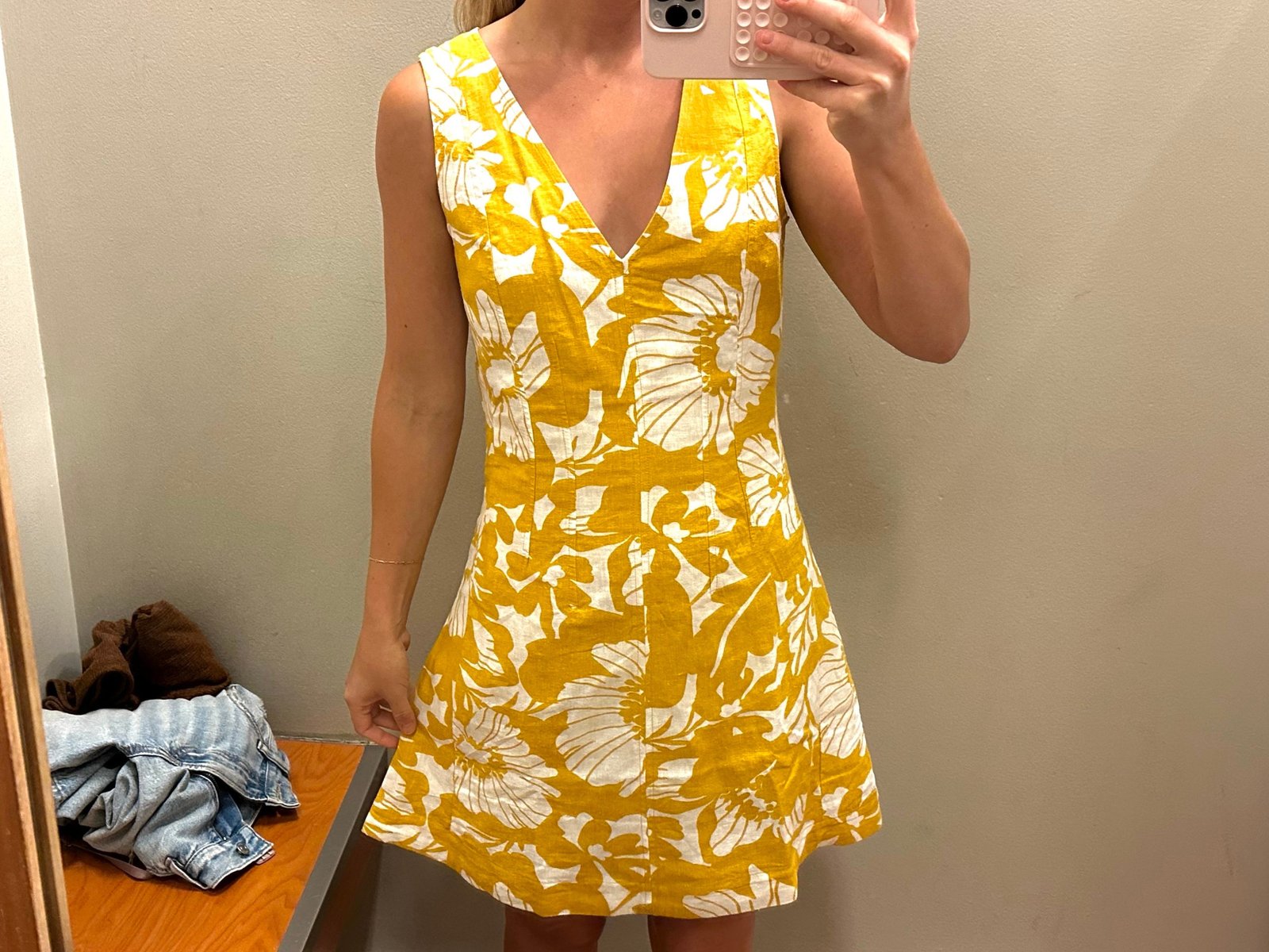 Chloe wearing a white and yellow floral dress in a Banana Republic fitting room.