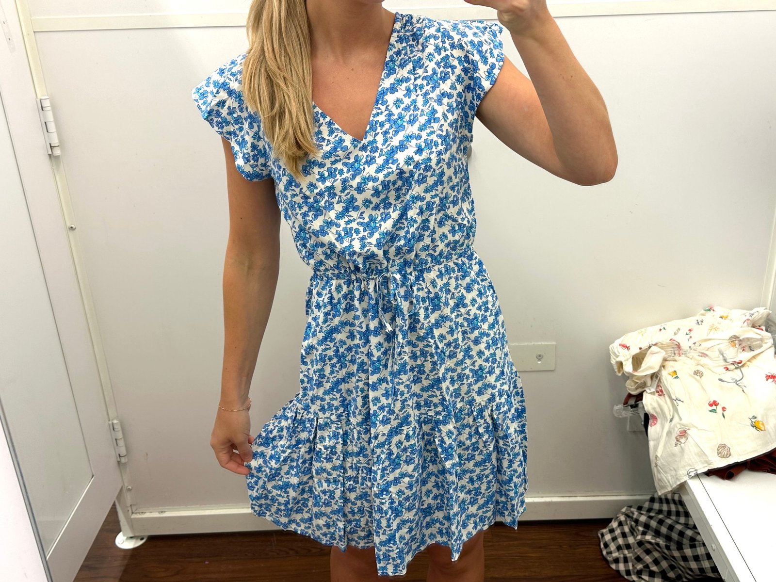 Chloe wearing a blue and white floral dress in a Gap fitting room.