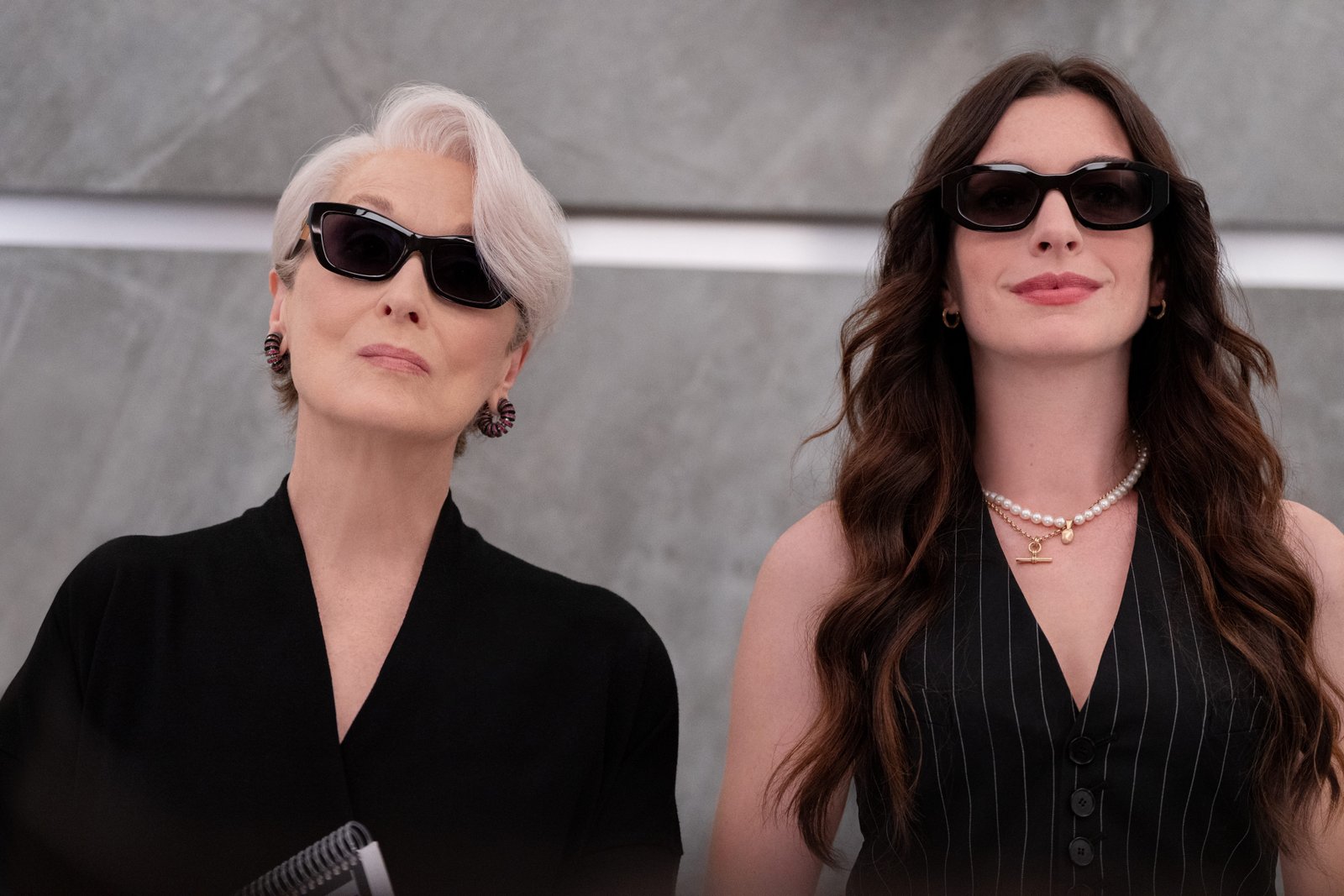 Meryl Streep and Anne Hathaway wearing dark sunglasses