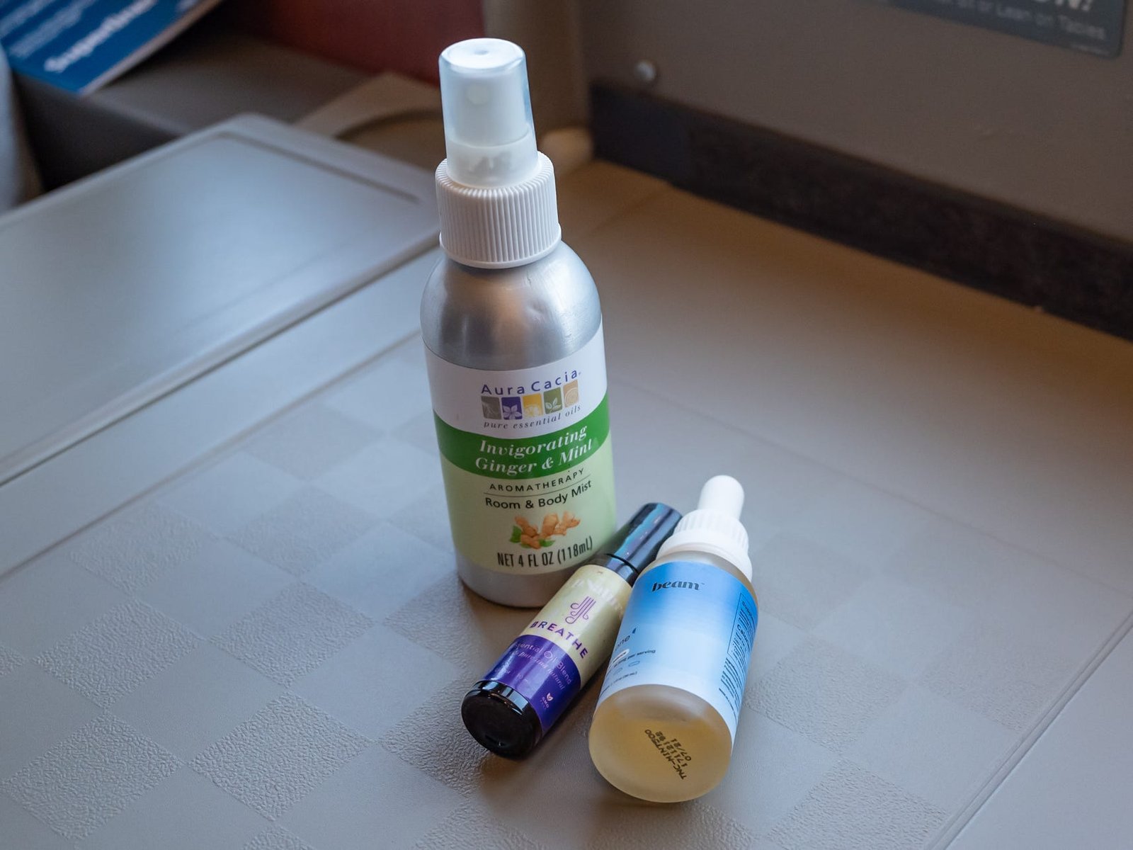 Three CBD and essential-oil bottles on a pull-out tray in an Amtrak car