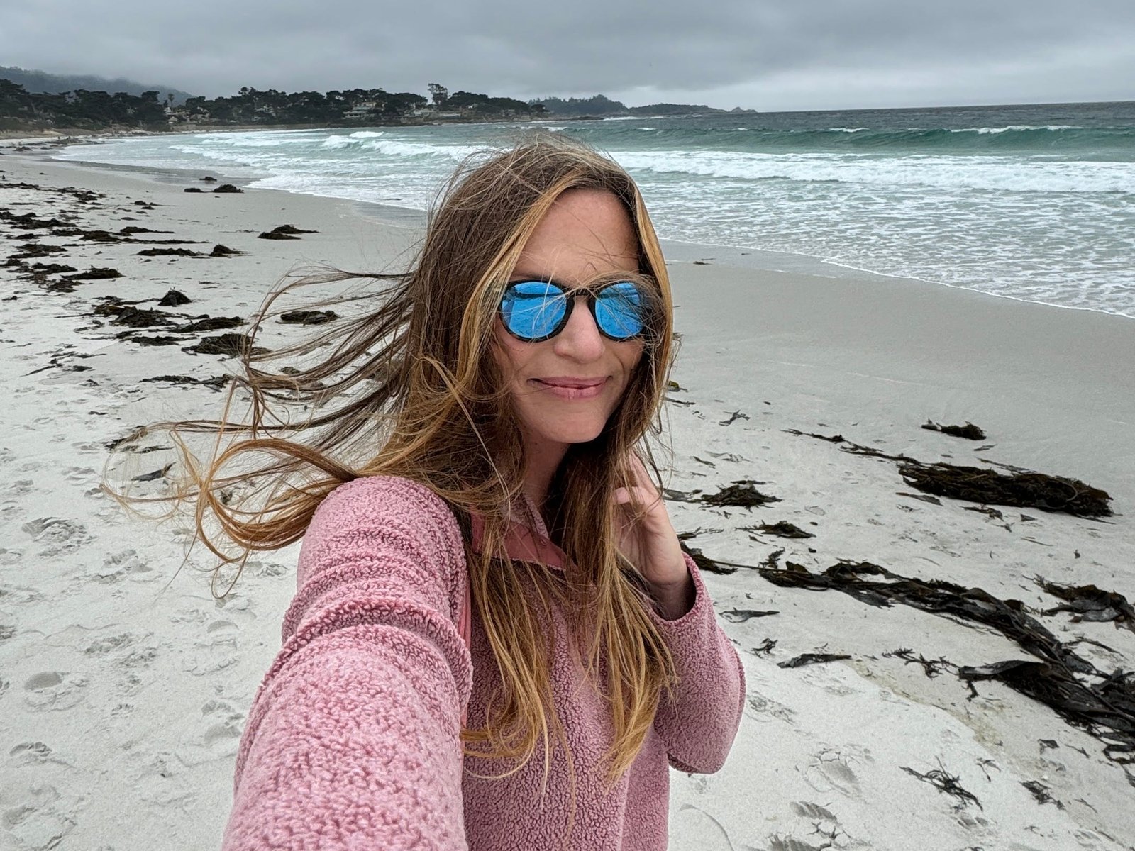 Emily taking a selfie at a beach in Carmel-by-the-Sea.