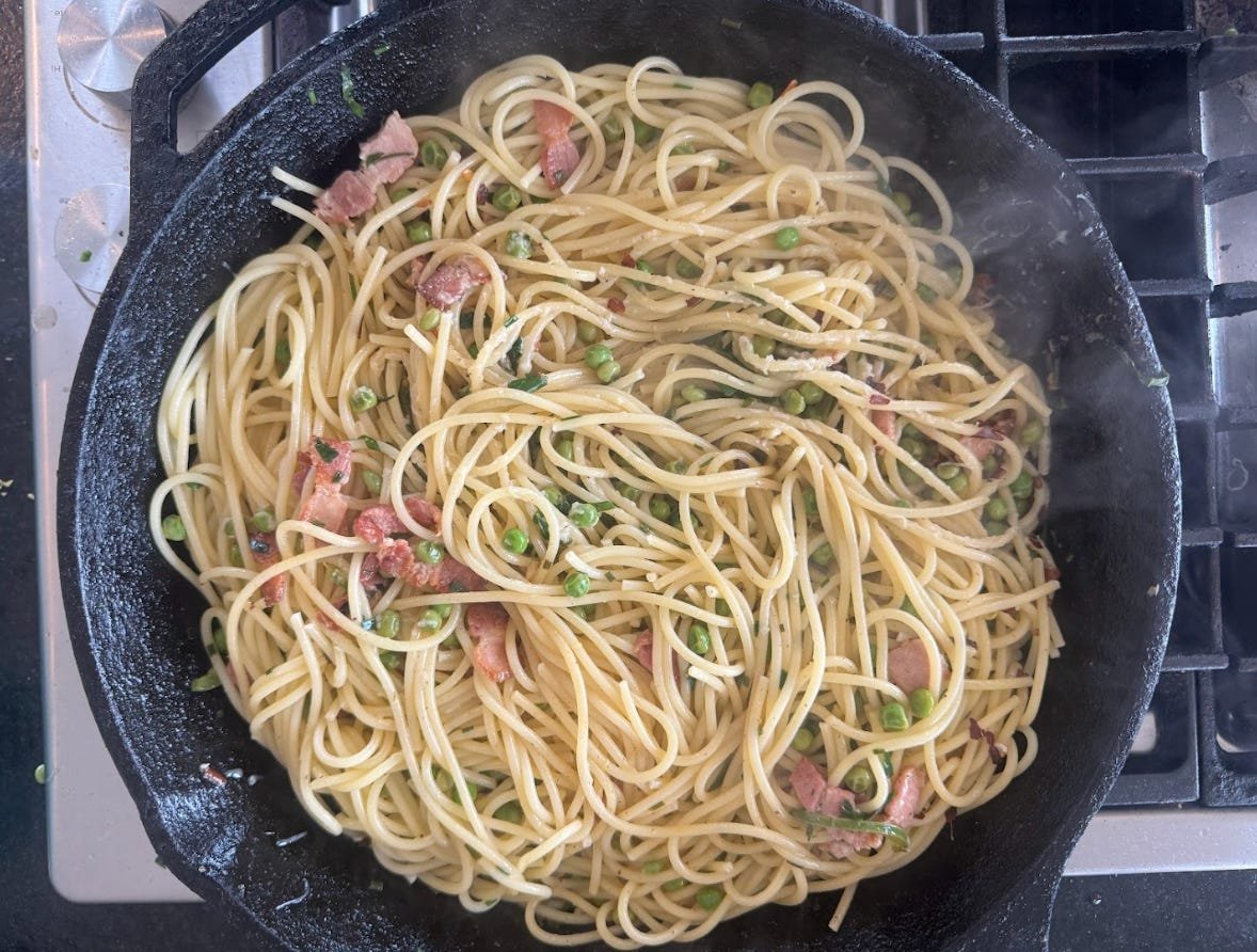 The pasta cooking with pancetta and peas.
