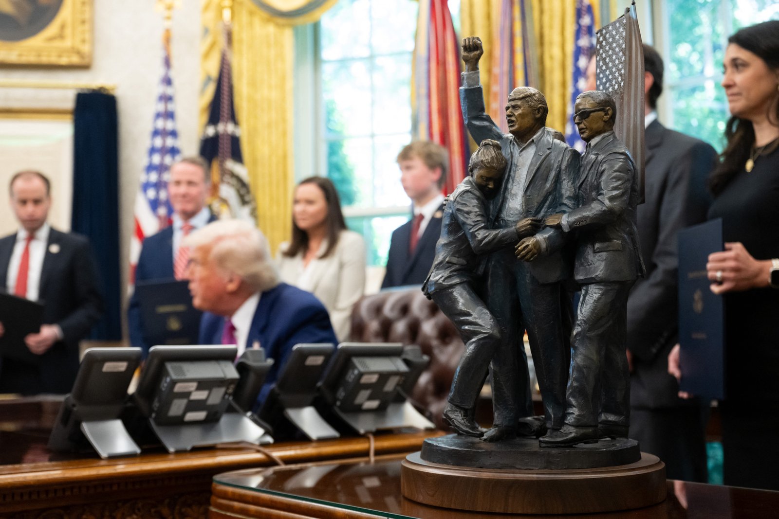 A statue depicting the attempted assassination of US President Donald Trump in Butler, Pennsylvania, sits alongside the Resolute Desk.