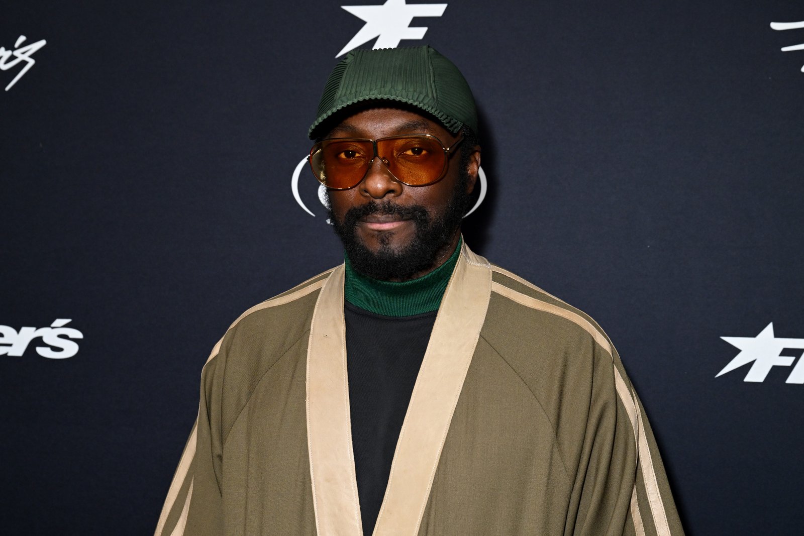 will.i.am in a green hat